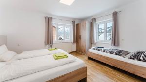 dwa łóżka w pokoju z dwoma oknami w obiekcie Moderne Ferienwohnung mit Bergblick w mieście Bad Goisern