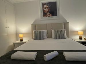 里斯本Quarto Aeroporto的卧室里有一张白色的大床,上面有两个枕头