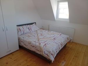 a small bedroom with a bed with a window at Čardak na padini Zlatibora in Ravni