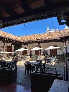 an outdoor patio with tables and chairs and umbrellas at Hotel cuenca antigua in Mazamitla