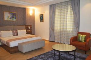 a hotel room with a bed and a chair at Caritas Inn Lekki in Lagos +20 photos