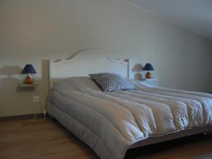Un dormitorio con una cama grande con dos lámparas. en La Calade, en Rosières 14 fotos más