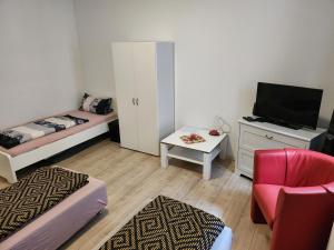 a small living room with a bed and a tv at MD- City, chic, Erdgeschoss, BESTPREIS- Leistung, wir bieten 1 Dreibettzimmer, plus DZ bis 5 Personen , Küche, Bad in Magdeburg