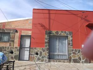 a red building with two windows on the side of it at Emilia II in Esquel
