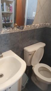 a bathroom with a white toilet and a sink at Casa pali in Miramar