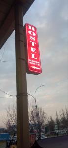 a red sign on the side of a gas station at Oltin Vodiy hostel in Fergana