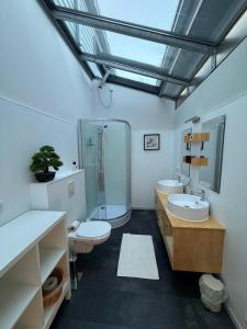 un ampio bagno con due lavandini e una doccia di Haus am See - Ferienwohnung mit Panoramablick ad Angermünde