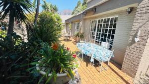un patio avec une table, des chaises et des plantes dans l'établissement Artzys Cottage 1km to Olivedale Clinic, à Northriding