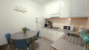 a kitchen with a sink and a table with blue chairs at Aura Guesthouse in Lagos