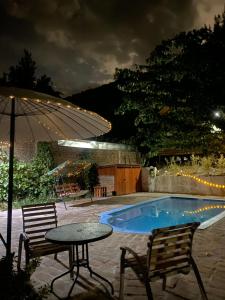 a patio with a table and chairs and a small pool at Cabañas Between Hills in San Alfonso