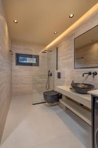 a bathroom with two sinks and a shower at Vadis Luxury Villa Rhodes in Koskinou
