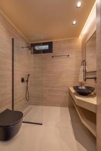 a bathroom with a glass shower and a sink at Vadis Luxury Villa Rhodes in Koskinou +18 photos