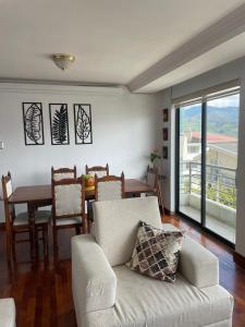 ein Wohnzimmer mit einem Sofa und einem Esstisch in der Unterkunft Acogedor departamento cerca al Terminal in Loja