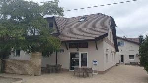 a building with tables and chairs in front of it at Mi Casa Vino in Mosonmagyaróvár