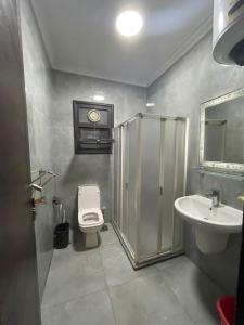 a bathroom with a shower and a toilet and a sink at Porto said بورتوسعيد شاليه غرفه وصاله للأسر فقط in `Ezbet Shalabi el-Rûdi