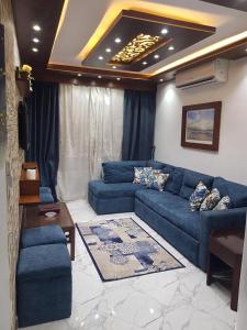 a living room with a blue couch and a table at Porto said بورتوسعيد شاليه غرفه وصاله للأسر فقط in `Ezbet Shalabi el-Rûdi