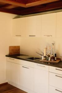 a kitchen with white cabinets and a sink at Tanafreida Berg-Refugium in Sankt Gallenkirch +91 photos