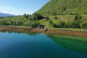 a view of a lake with a house in the background at Nesset i Fiskfjord in Dragland +41 photos