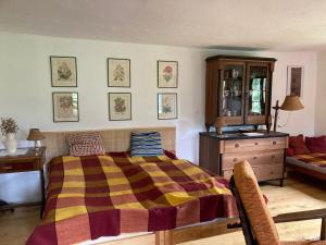 een slaapkamer met een bed, een dressoir en een bank bij Dvůr Metlice in Rožmberk nad Vltavou