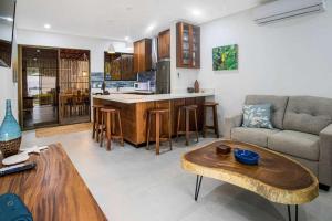 Una cocina y una sala de estar con un sofá y una mesa. en Minimalist Condo with a Beautiful New Design, Bound Patio, and Shared Community Pool, en Coco