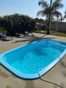 a large blue swimming pool in a yard at pousada ranchinho sorocaba in Sorocaba