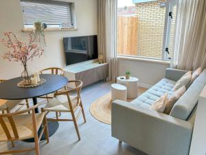 a living room with a couch and a table and a tv at Casa Bon Bini in Egmond aan Zee
