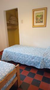 a bedroom with two beds and a checkered floor at La Guadalupana in Mina Clavero