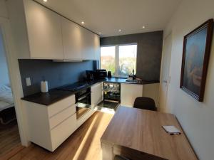 a kitchen with white cabinets and a wooden table at Fjeldgaard Rug 1sal in Odense