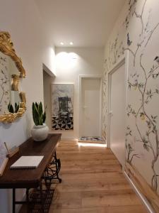 un pasillo con una mesa y una pintura en la pared en MAGGESE Dimora di Charme, en Palermo