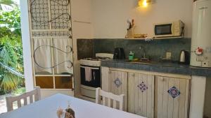 a kitchen with a stove and a table and a microwave at La Guadalupana in Mina Clavero