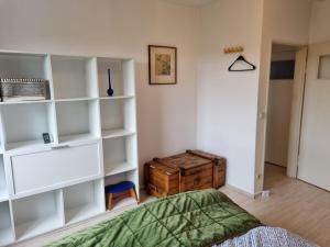 a bedroom with white shelves and a bed and a wooden chest at Tischfussball Quartier Köln-Niehl in Cologne