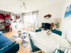 a living room with a white table and a blue couch at - Le COSY GARDEN - Proche RER A et E - Paris Disney - Parking et WIFI Gratuit ! Family SPECIAL OFFER in Champigny-sur-Marne