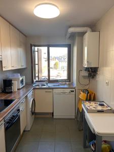 a small kitchen with white appliances and a window at Lunar in Castiello de Jaca