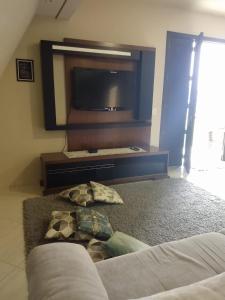 een woonkamer met een tv en een bank bij Chalé Bem-Estar in Massaranduba