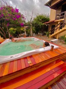 dos personas en una bañera de hidromasaje en una terraza en Apartamento com vista panorâmica em Bombas, en Bombinhas