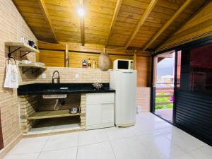 una cocina con fregadero y refrigerador en Apartamento com vista panorâmica em Bombas, en Bombinhas 23 fotos más