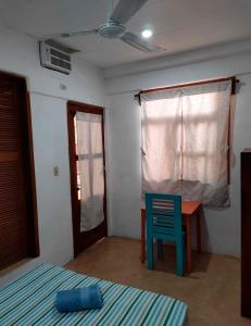 a bedroom with a desk and a blue chair at Hotel Papaya Surf in Puerto Escondido