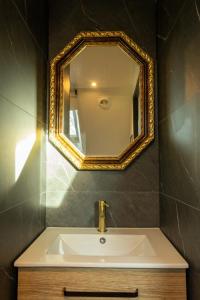 a bathroom with a sink and a mirror on the wall at Le Glam Divin in Nantes +25 photos