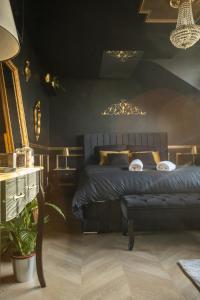 a bedroom with a bed with a bench and a chandelier at Le Glam Divin in Nantes