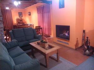 sala de estar con 2 sofás azules y chimenea en Casa Rural Pájaro Bobo, en Bustares