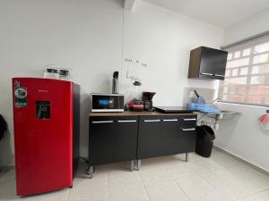 a kitchen with a red refrigerator and a counter at Casa Vacacional Maya Comitan in Comitán