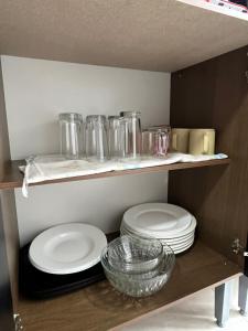 a shelf with plates and glass dishes on it at Casa Vacacional Maya Comitan in Comitán +10 photos
