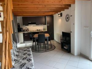 a kitchen with a table and a dining room at Gîte cocon Vassivière Aux abords du lac in Lac de Vassivière