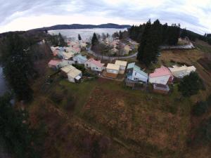 a group of houses on a hill next to a body of water at Gîte cocon Vassivière Aux abords du lac in Lac de Vassivière