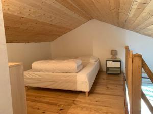 a bed in a room with a wooden ceiling at Gîte cocon Vassivière Aux abords du lac in Lac de Vassivière