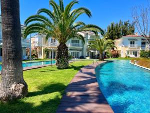 una grande casa con piscina e palme di Portville 65 Central Luxurious Villa in Portville Gocek a Fethiye