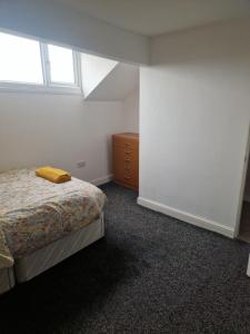 Un dormitorio con una cama y una cómoda y una ventana. en En-Suite Double Room in Haughton Green Denton M34, en Haughton Green 1 foto más