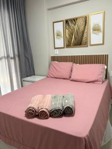 uma cama rosa com três pares de toalhas em Novo Apt Piscina, Praia & Farol Barra em Salvador mais 88 fotografias