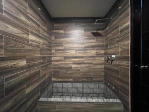 a bathroom with a shower with wooden walls at Holiday House - 3 Bedroom 3 Bathroom in Baños