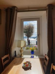 a dining room table with a view of a window at Carnaburg Guesthouse in Tobermory